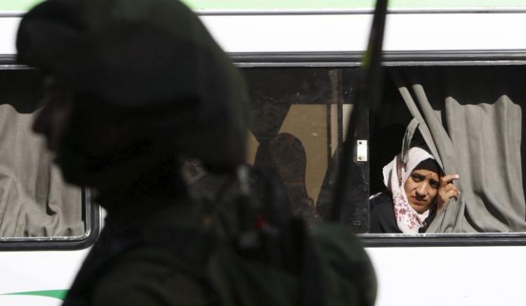Palestinian woman looks out a bus window in Hebron, West Bank / CNS photo