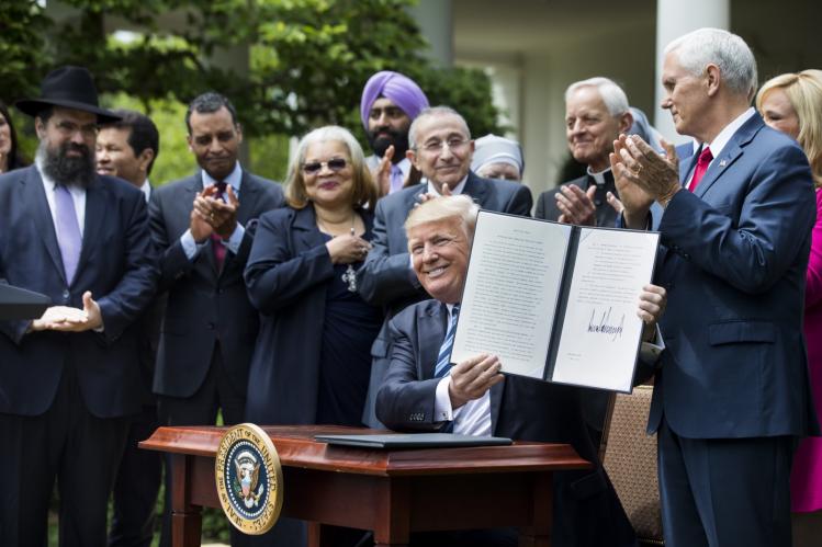 Donald Trump shows his signed Executive Order on Promoting Free Speech and Religious Liberty in May 2017 / CNS photo