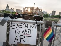 A protest sign against Sam Durant’s “Scaffold” sculpture on the perimeter fence of the Walker Art Center's sculpture garden / flickr - Lorie Shaull