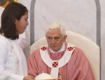 A girl altar server carries Pope Benedict XVI's zucchetto during his visit to St. Maximilian Kolbe Parish in Rome